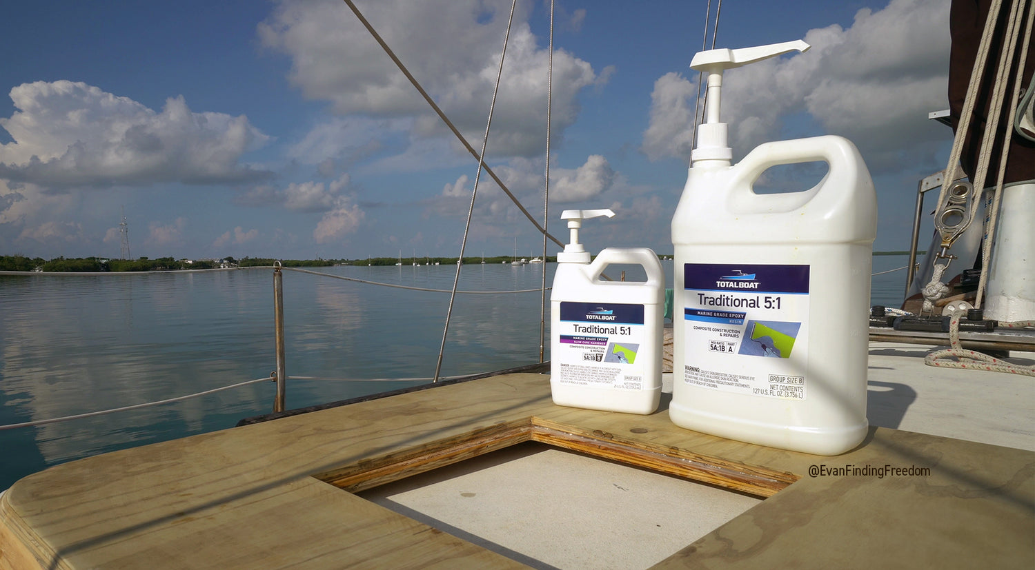 Traditional 5:1 Marine Epoxy bottles with pumps on the deck of a sailboat. The epoxy is being used to adhere two pieces of marine-grade plywood with a hatch cut out. It's all hapening out on the water.
