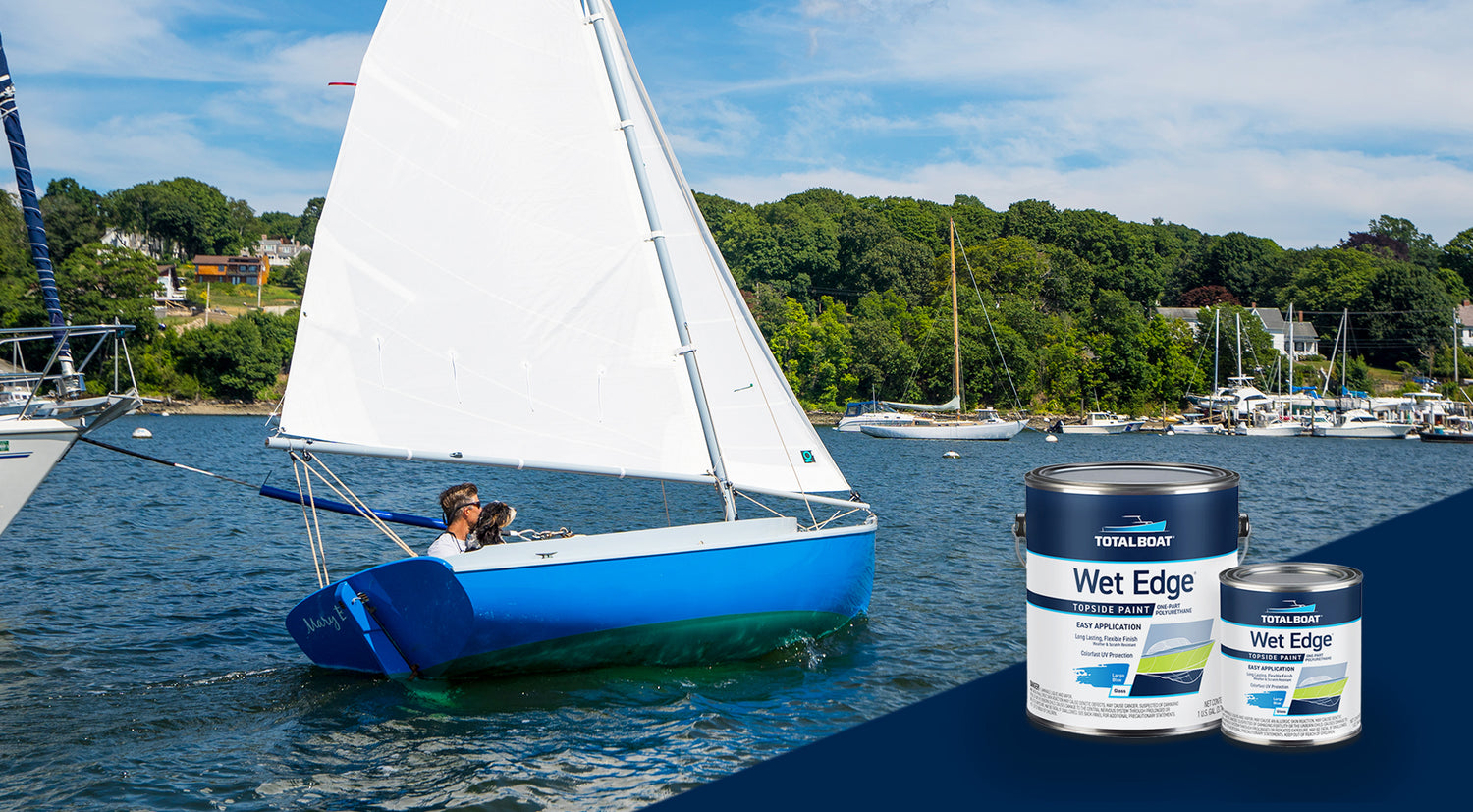 A sailor/do-it-yourselfer and his dog out on the bay in their Levant 15 sailboat, which is sporting a shiny, TotalBoat Wet Edge Topsdie Paint job in Largo Blue.