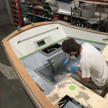 TotalBoat 2-Part Epoxy Primer Gray being applied inside a boat with a roller