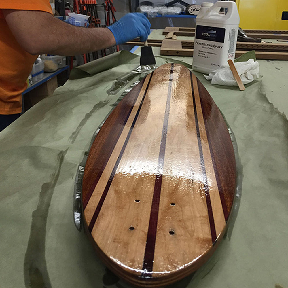 TotalBoat Penetrating Epoxy Sealer being brushed on a board